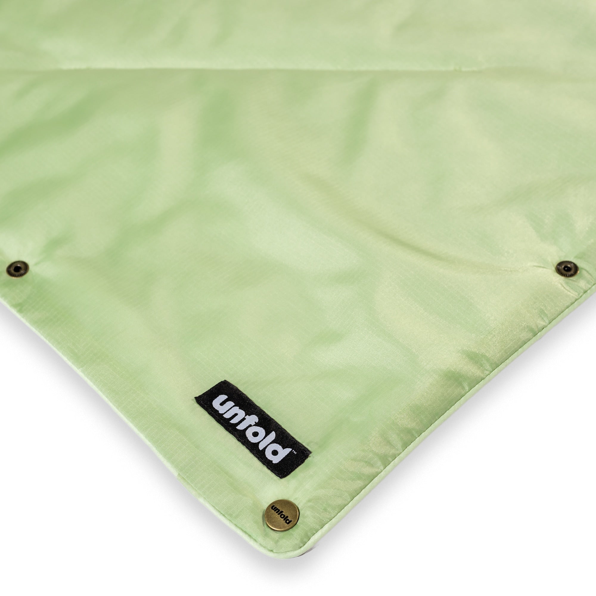 Grüne Reisedecke in Salbei von UNFOLD mit Logo und Knöpfen