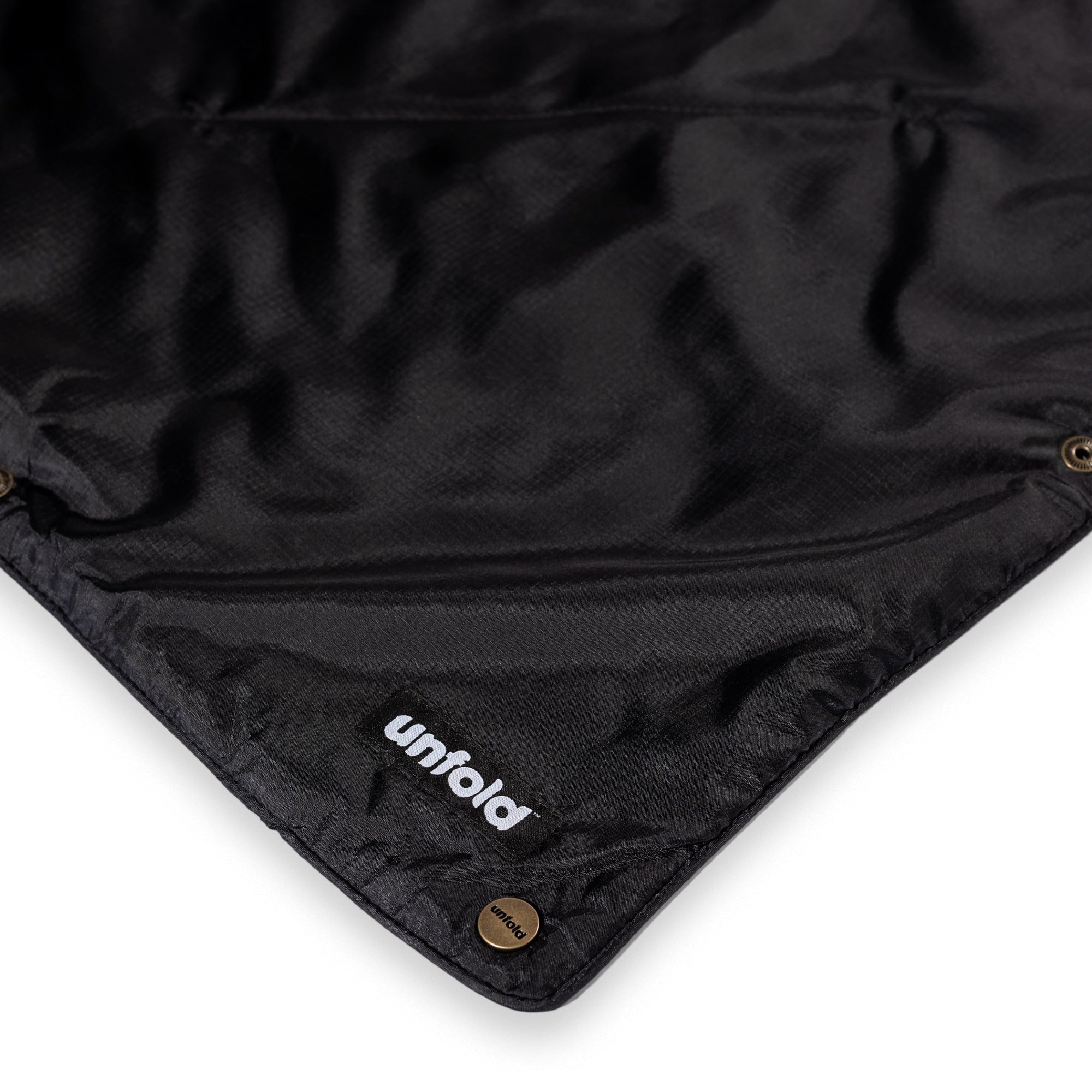 Schwarze Reisedeck von UNFOLD vordere Ecke mit Knöpfen und Logo