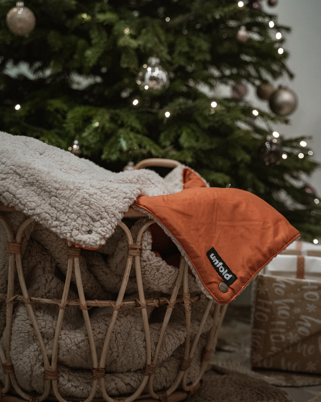kuschelige Decke in Korb vor Weihnachtsbaum